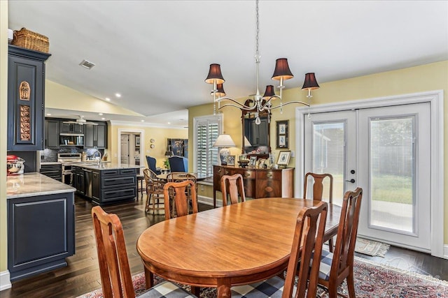 dining room featuring an inviting chandelier, french doors, dark wood finished floors, lofted ceiling, and visible vents