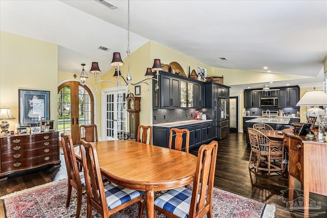 dining room with visible vents, vaulted ceiling, french doors, and dark wood finished floors