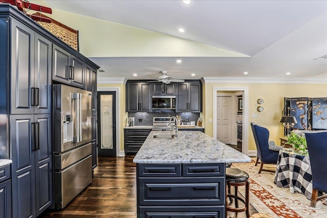 kitchen with ornamental molding, lofted ceiling, appliances with stainless steel finishes, and a sink