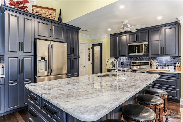 kitchen featuring a sink, ceiling fan, appliances with stainless steel finishes, light stone countertops, and visible vents