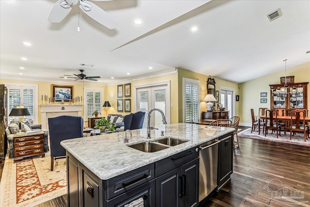 kitchen featuring stainless steel dishwasher, a sink, ceiling fan, dark cabinets, and visible vents