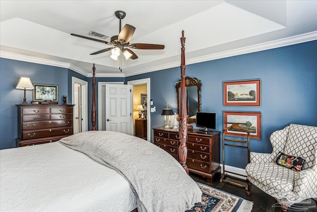 bedroom featuring baseboards, wood finished floors, visible vents, and ornamental molding