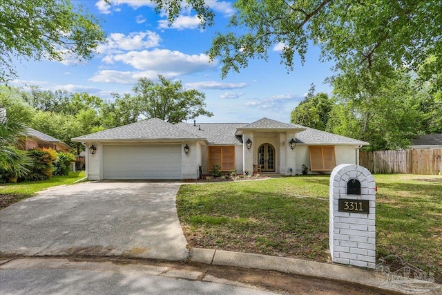 view of front of house with french doors, a front lawn, concrete driveway, fence, and an attached garage