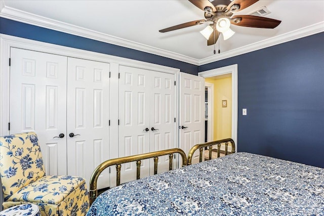 bedroom with ceiling fan, crown molding, multiple closets, and visible vents