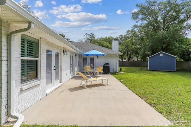 view of patio with fence, a storage unit, french doors, and an outdoor structure