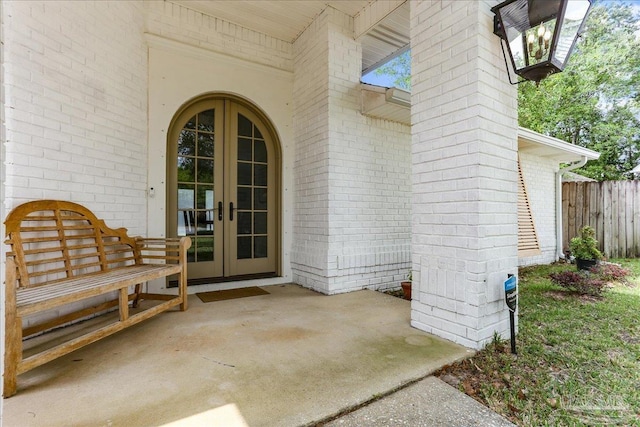 doorway to property featuring french doors and brick siding