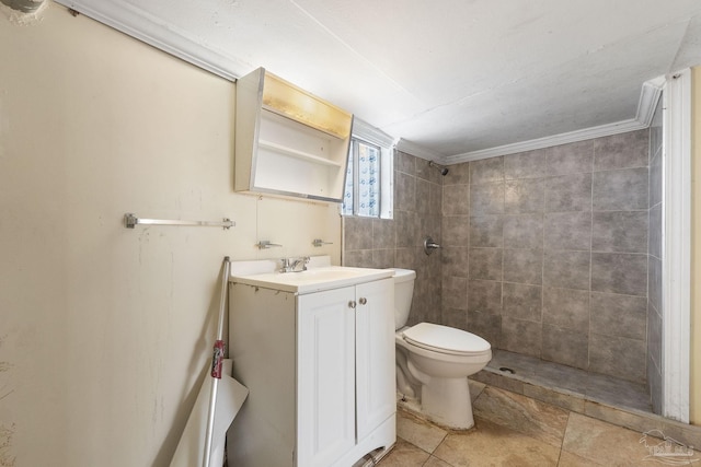 bathroom with tiled shower, vanity, crown molding, toilet, and tile patterned floors