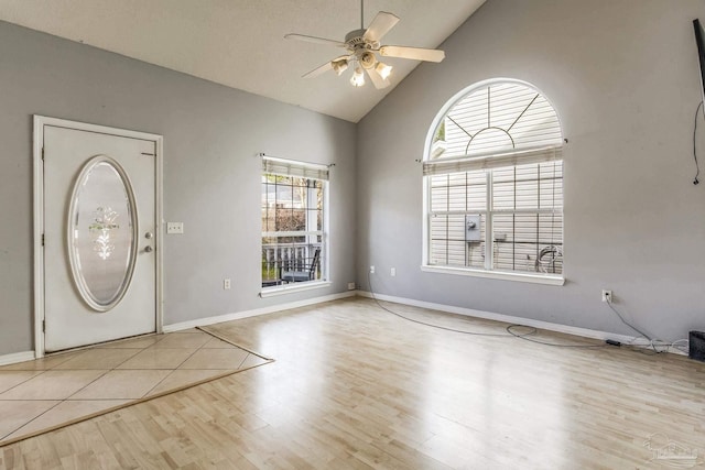 foyer featuring ceiling fan, light wood-type flooring, and vaulted ceiling