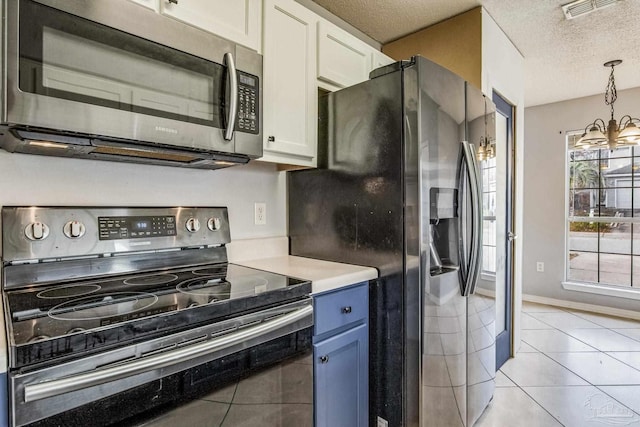 kitchen featuring a chandelier, stainless steel appliances, white cabinetry, and light tile patterned flooring