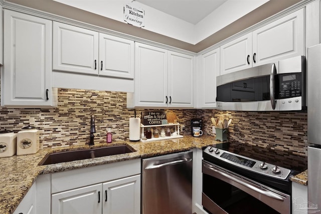 kitchen with sink, stainless steel appliances, white cabinetry, and tasteful backsplash