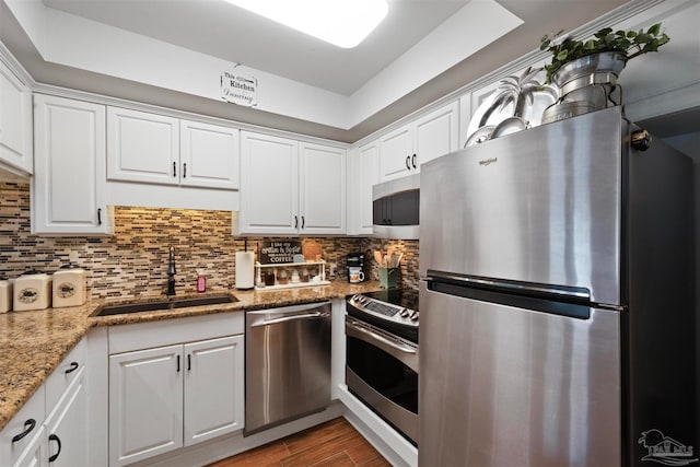 kitchen featuring appliances with stainless steel finishes, sink, backsplash, and white cabinets