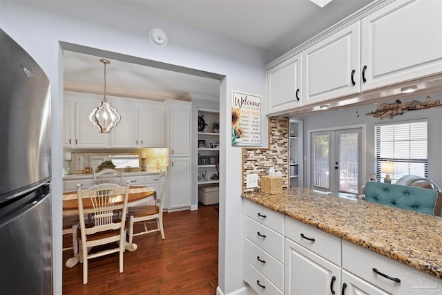 kitchen featuring dark hardwood / wood-style flooring, tasteful backsplash, french doors, white cabinetry, and stainless steel fridge