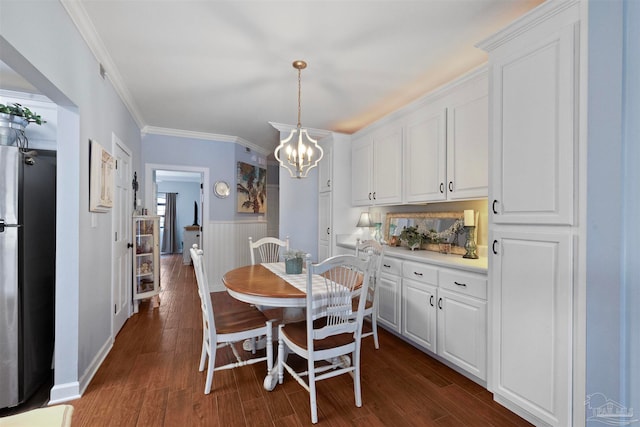 dining area featuring a notable chandelier, crown molding, and dark hardwood / wood-style floors