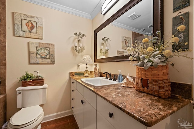 bathroom with ornamental molding, vanity, and toilet