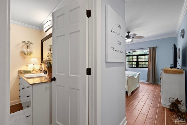 hall featuring sink, crown molding, and wood-type flooring