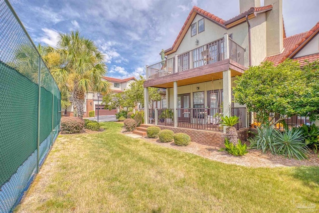 view of yard featuring a balcony and covered porch