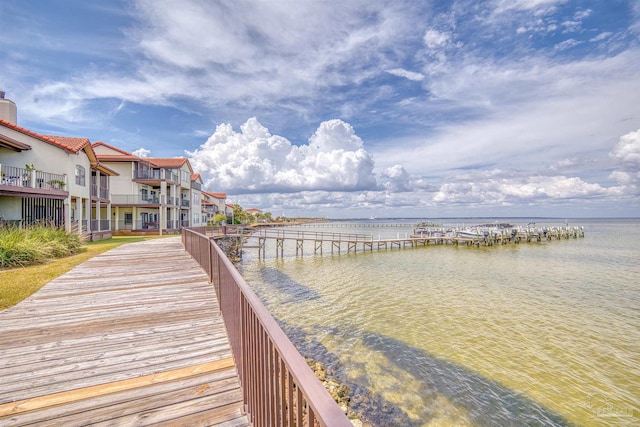 dock area with a balcony and a water view