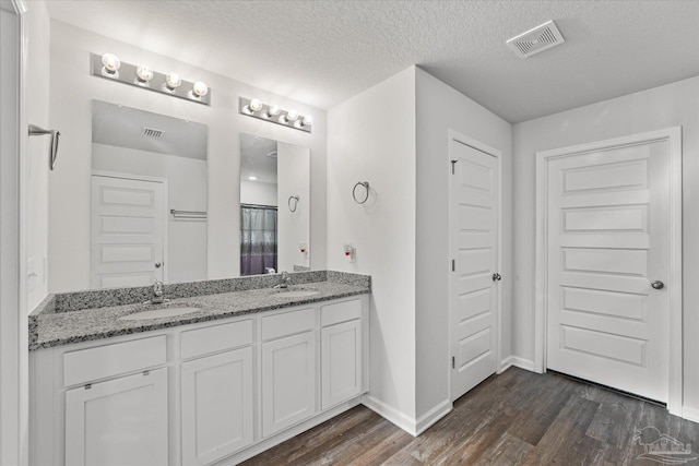 bathroom featuring hardwood / wood-style flooring, a textured ceiling, and vanity