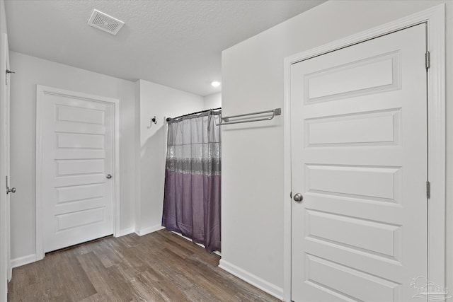 bathroom with a shower with shower curtain, a textured ceiling, and hardwood / wood-style flooring