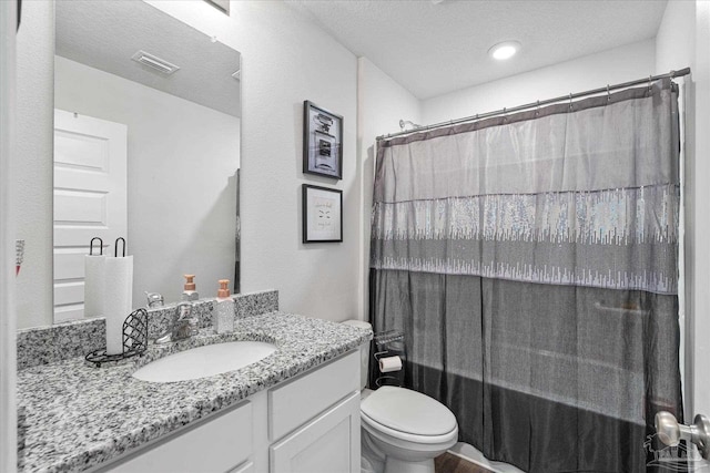 bathroom featuring a textured ceiling, toilet, vanity, and a shower with shower curtain