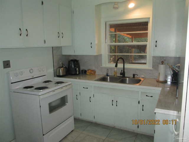 kitchen featuring white cabinetry, sink, decorative backsplash, and electric stove