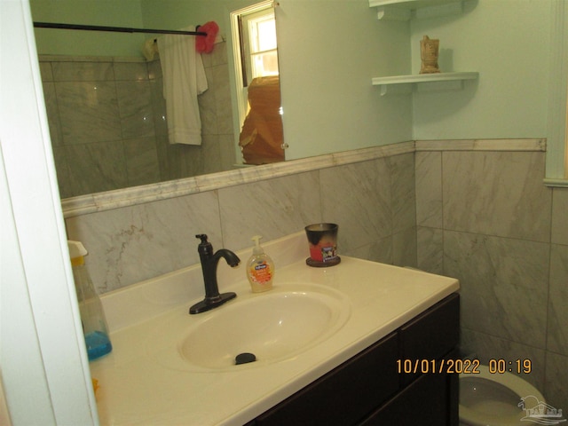 bathroom featuring vanity, tile walls, and walk in shower