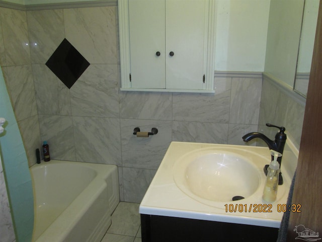 bathroom featuring vanity, a tub, and tile walls