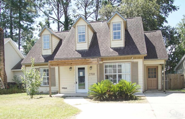 cape cod-style house featuring a front lawn and a porch