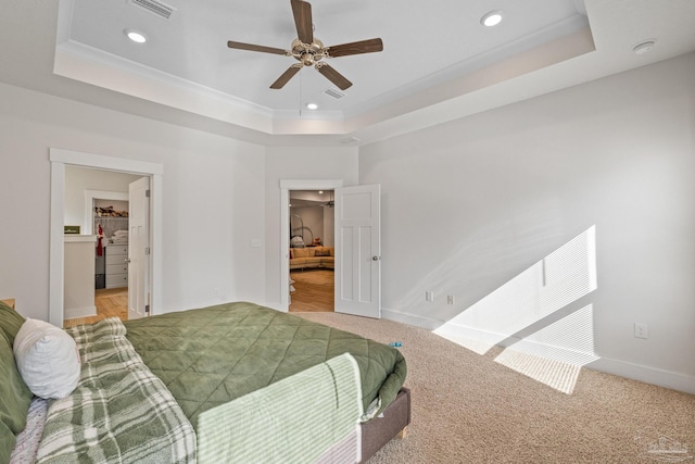 bedroom with ornamental molding, a raised ceiling, ceiling fan, and light carpet