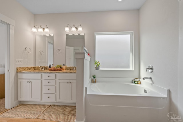 bathroom featuring a bathtub, tile patterned flooring, and vanity