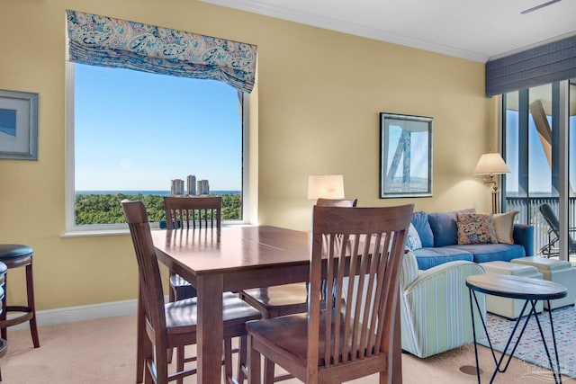 dining room with crown molding, light colored carpet, and a healthy amount of sunlight