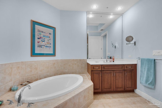 bathroom featuring vanity, a relaxing tiled tub, and tile patterned flooring