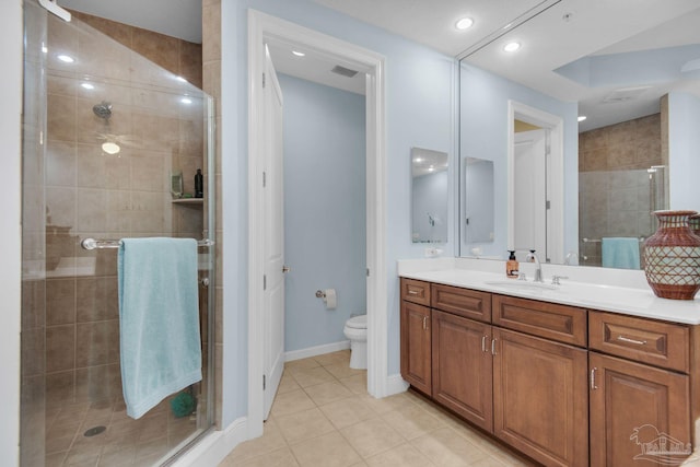 bathroom featuring vanity, toilet, a shower with shower door, and tile patterned flooring