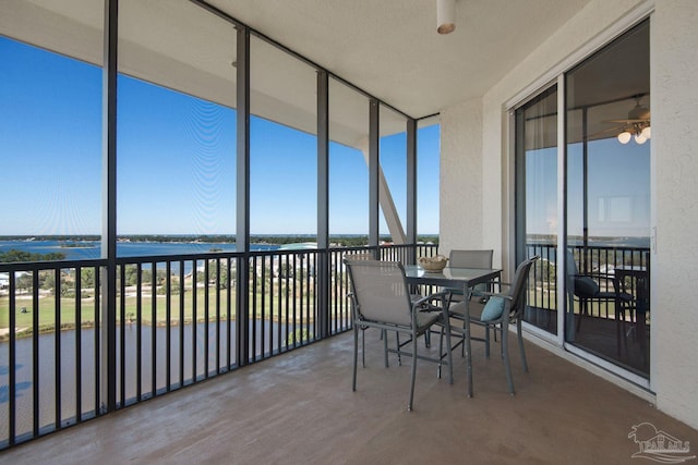 unfurnished sunroom with a water view and ceiling fan