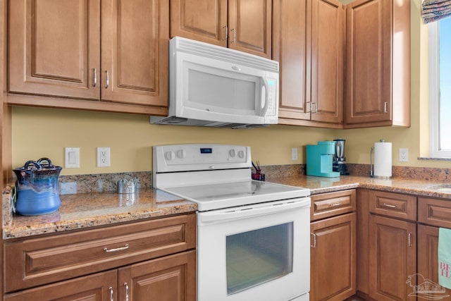 kitchen with white appliances and light stone countertops