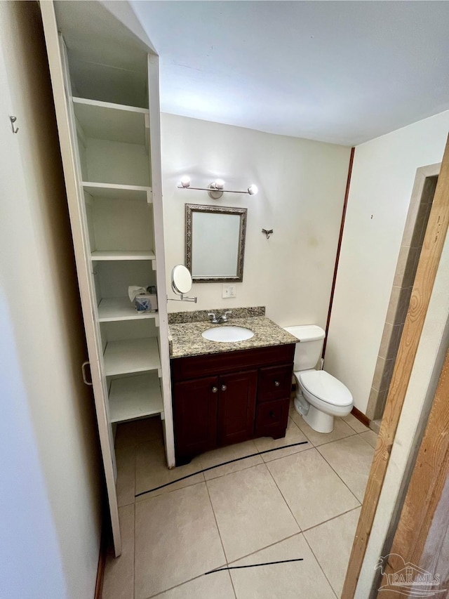 bathroom featuring tile patterned flooring, vanity, and toilet