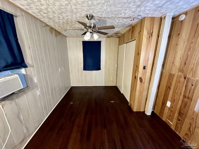 interior space featuring cooling unit, wooden walls, and wood finished floors