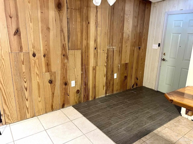 interior space with tile patterned flooring and wooden walls