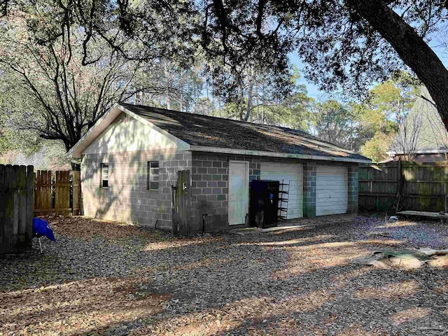 detached garage featuring fence