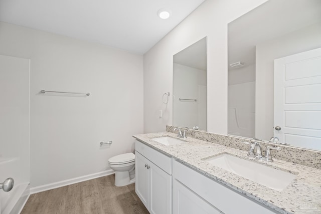 bathroom with walk in shower, vanity, wood-type flooring, and toilet