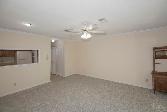 unfurnished room featuring ceiling fan, light carpet, and ornamental molding