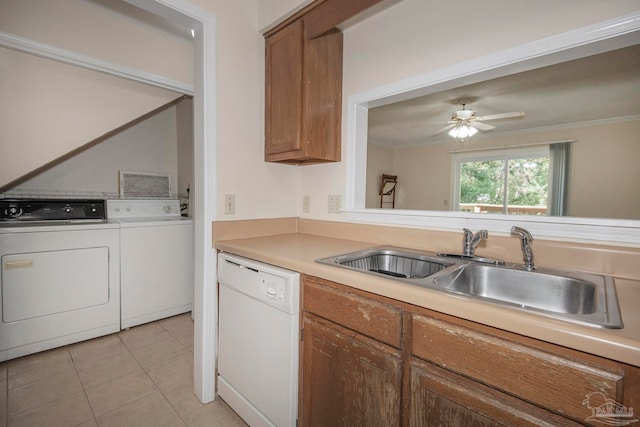 kitchen featuring sink, white dishwasher, light tile patterned floors, independent washer and dryer, and crown molding