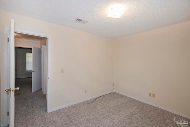 unfurnished room with carpet and a textured ceiling