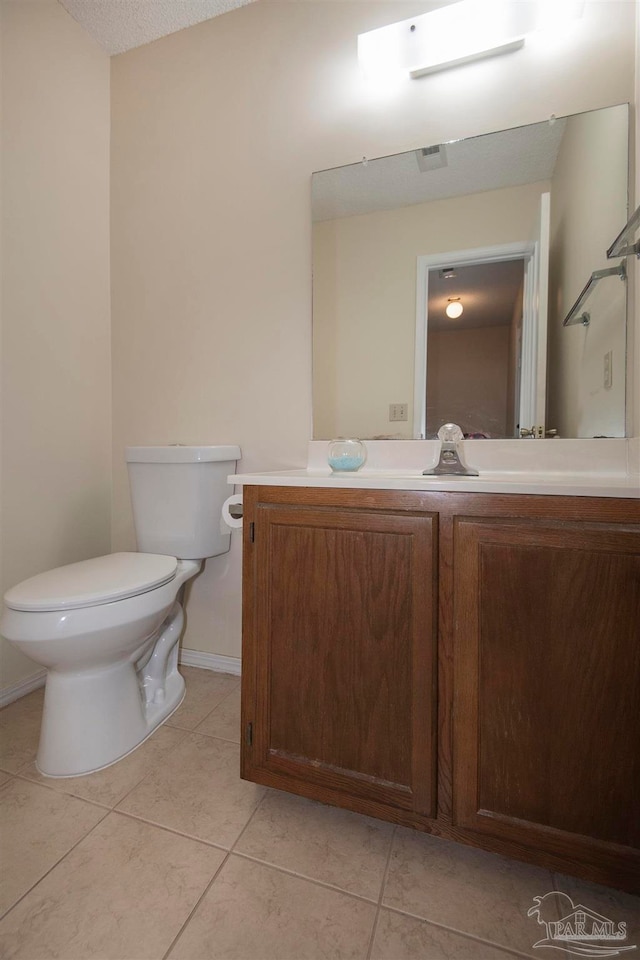 bathroom with tile patterned flooring, vanity, and toilet