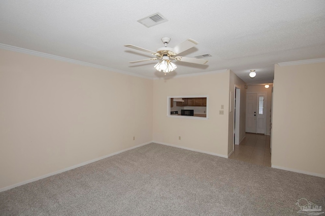 carpeted empty room featuring a textured ceiling, ceiling fan, and crown molding