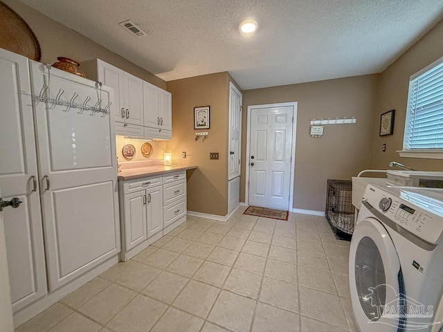 5020 Lantana Dr, Gulf Breeze, FL 32563 - laundry room with a textured ceiling, cabinet space, baseboards, washer and dryer, and light tile patterned flooring