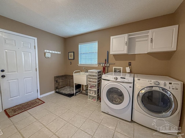 5020 Lantana Dr, Gulf Breeze, FL 32563 - clothes washing area with cabinet space, washer and clothes dryer, a textured ceiling, light tile patterned floors, and baseboards
