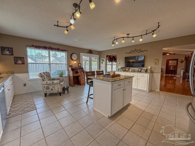 5020 Lantana Dr, Gulf Breeze, FL 32563 - kitchen featuring light tile patterned floors, track lighting, white cabinets, healthy amount of natural light, and a textured ceiling