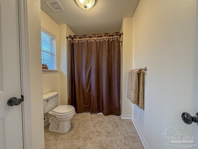 5020 Lantana Dr, Gulf Breeze, FL 32563 - full bathroom with a shower with curtain, toilet, and a textured ceiling