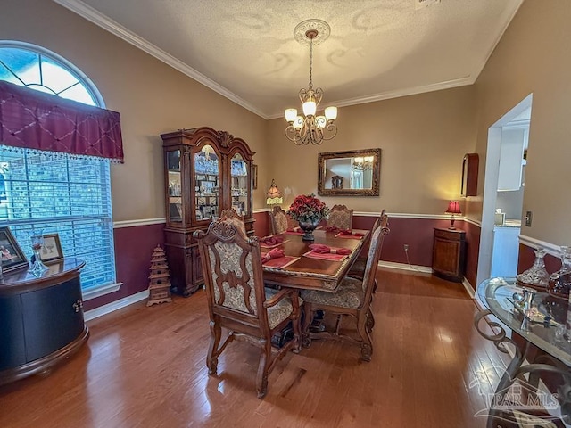 5020 Lantana Dr, Gulf Breeze, FL 32563 - dining space with a chandelier, wood finished floors, crown molding, baseboards, and a textured ceiling